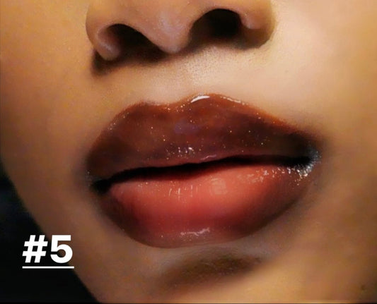 Chocolate #5 - Glossy Gang Close - up of shimmering glitter gloss applied to lips, showcasing a sparkly, reflective finish."