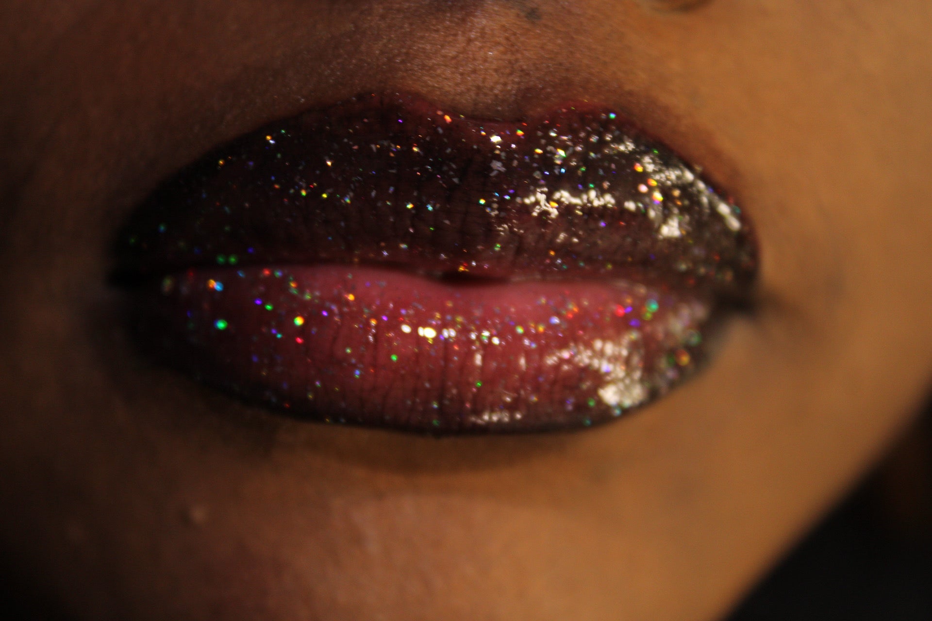 Raven #1 - Glossy Gang Lip GlossClose - up of shimmering glitter gloss applied to lips, showcasing a sparkly, reflective finish."