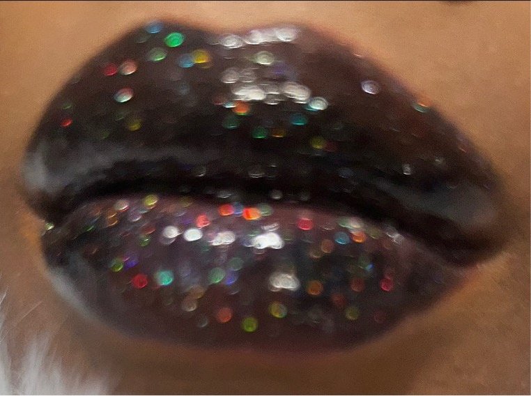 Raven #1 - Glossy Gang Lip GlossClose - up of shimmering glitter gloss applied to lips, showcasing a sparkly, reflective finish."