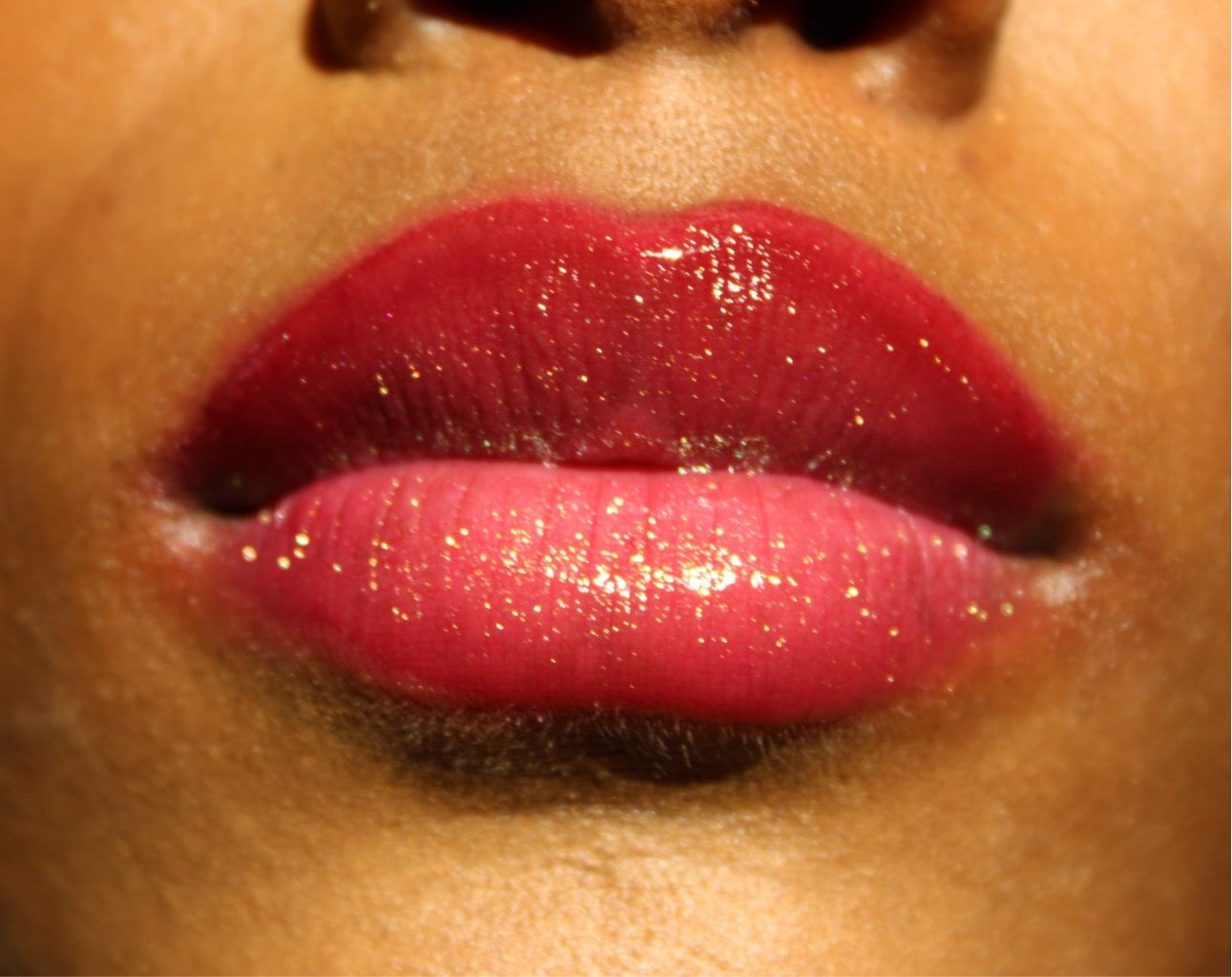 Ruby #8 - Glossy Gang Lip GlossClose - up of shimmering glitter gloss applied to lips, showcasing a sparkly, reflective finish."