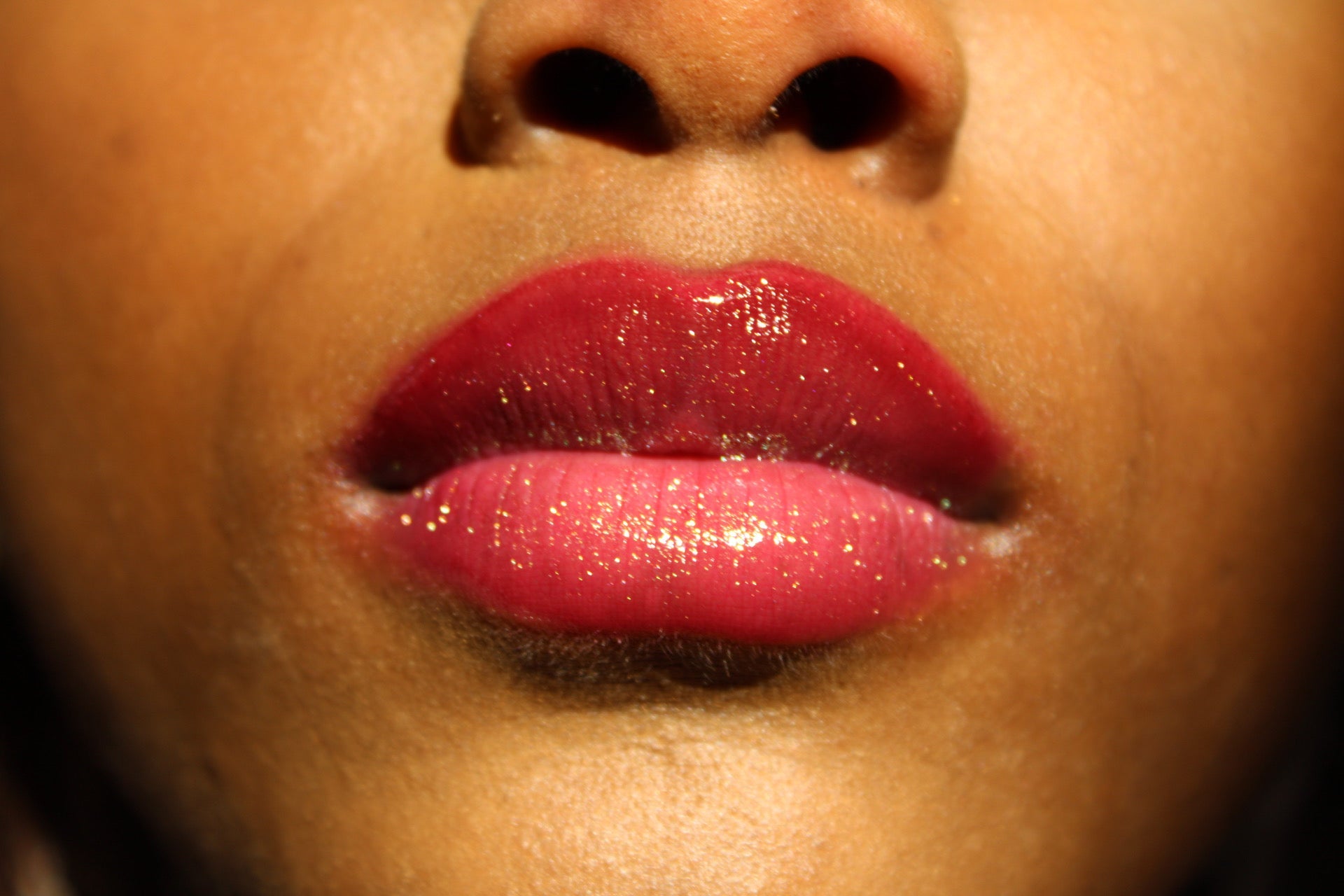 Ruby #8 - Glossy Gang Lip GlossClose - up of shimmering glitter gloss applied to lips, showcasing a sparkly, reflective finish."