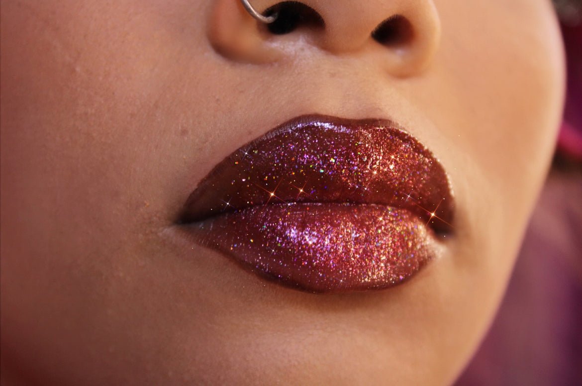 Velvet #13 - Glossy Gang Lip GlossClose - up of shimmering glitter gloss applied to lips, showcasing a sparkly, reflective finish."